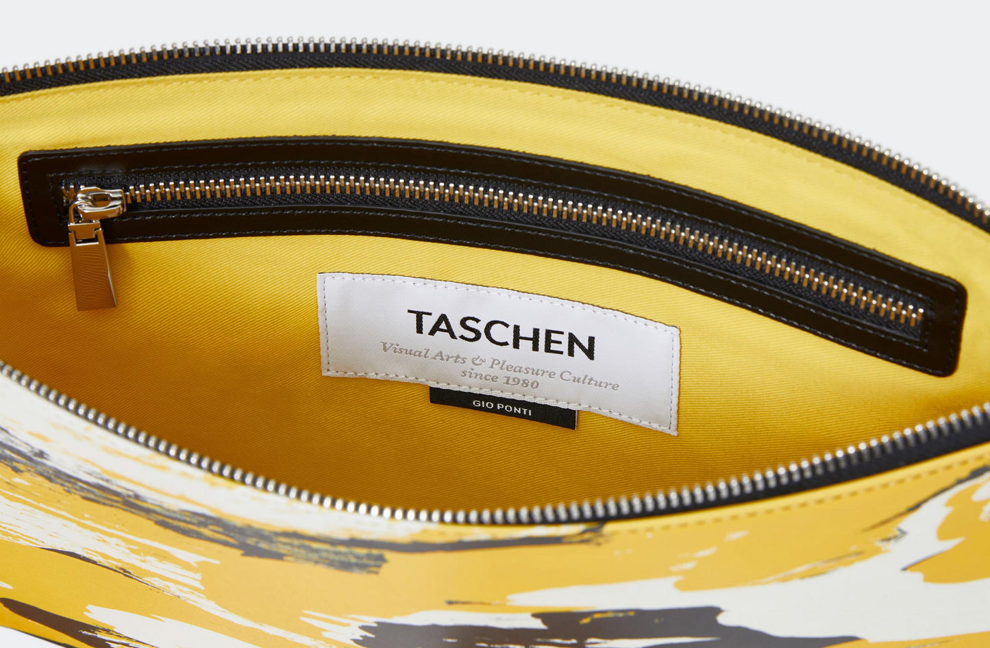 Yellow bag with a visible Taschen and Gio Ponti label on a white background