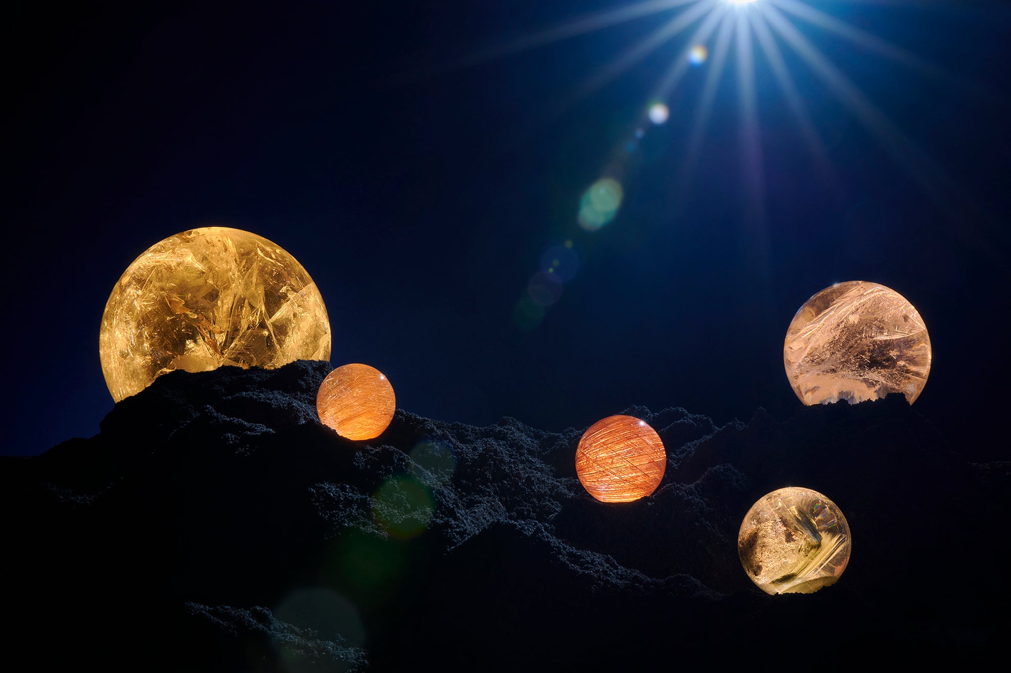 Quartz Spheres  from the Dorow Collection displayed on sand against a dark background